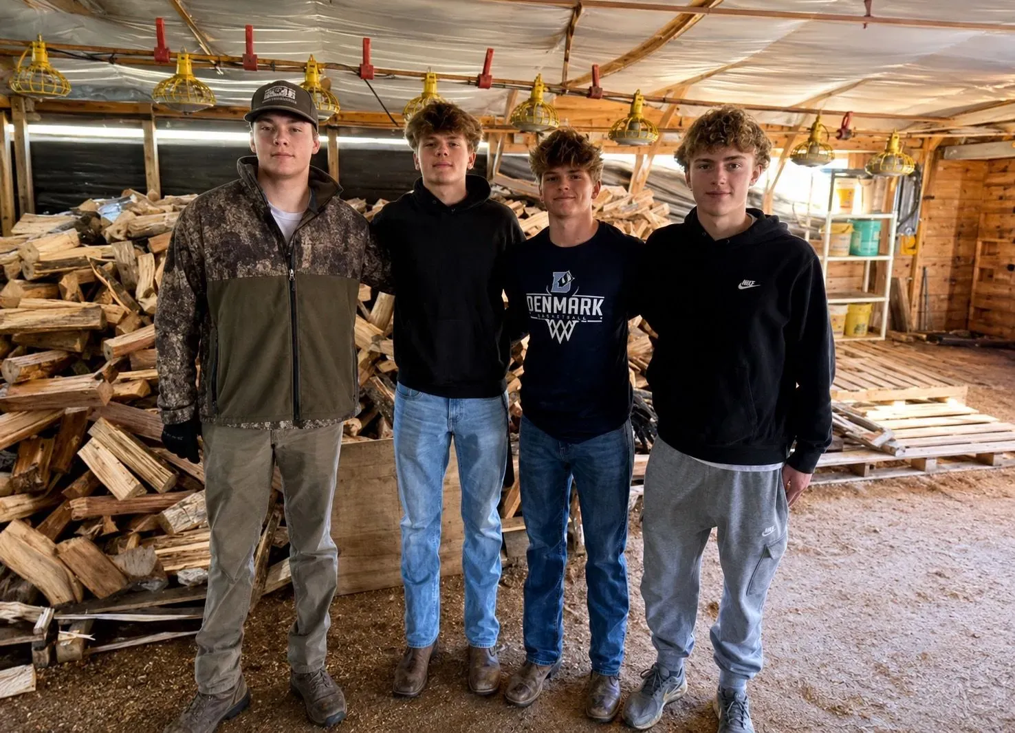 Four members of the High School Firewood crew in the barn