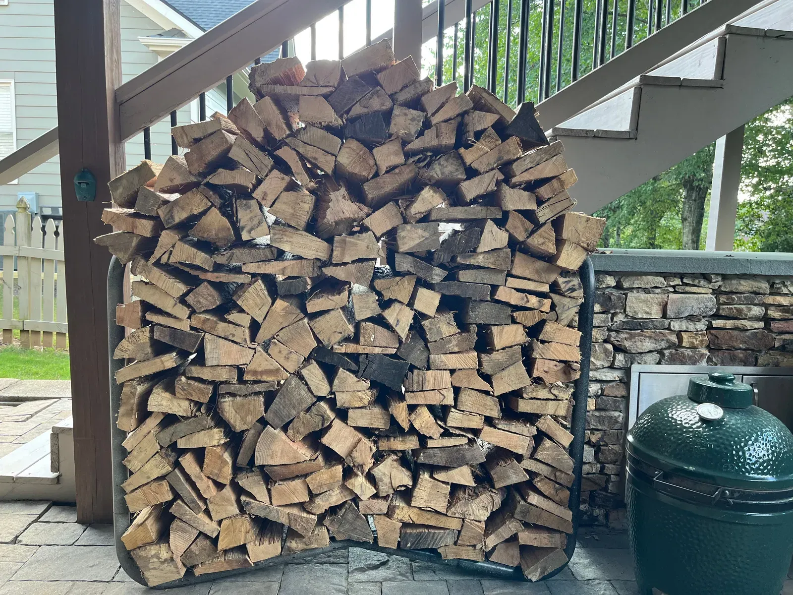 A full rack of firewood stacked neatly at a home